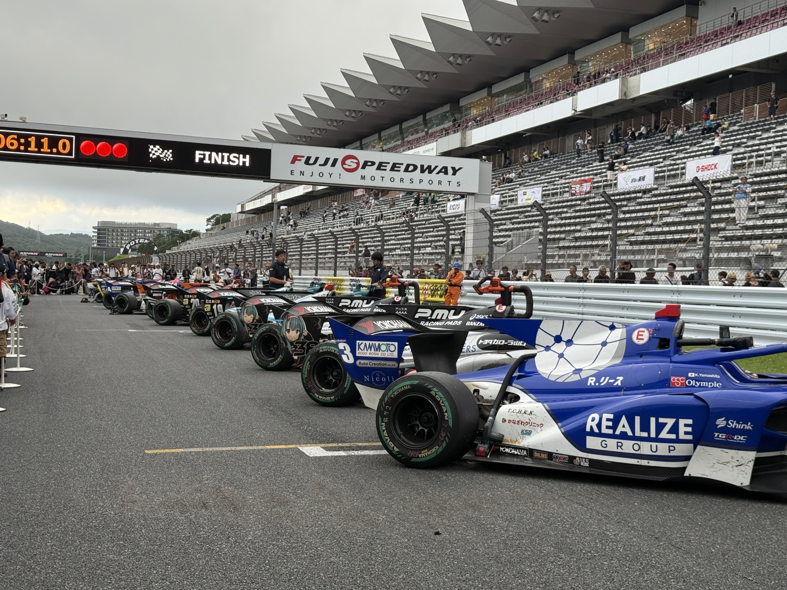 Super Formula cars lined up in the pit lane at Fuji Speedway.